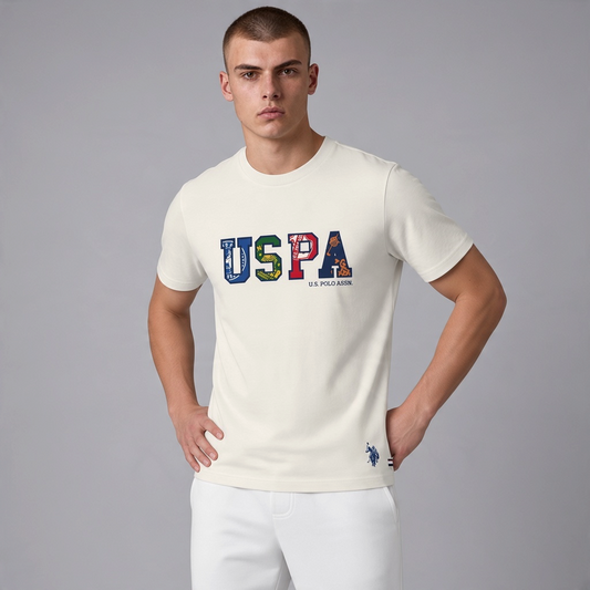 Hombre vistiendo camiseta de algodón color crema www.treshop.com.co con logo USPA estampado y cuello redondo