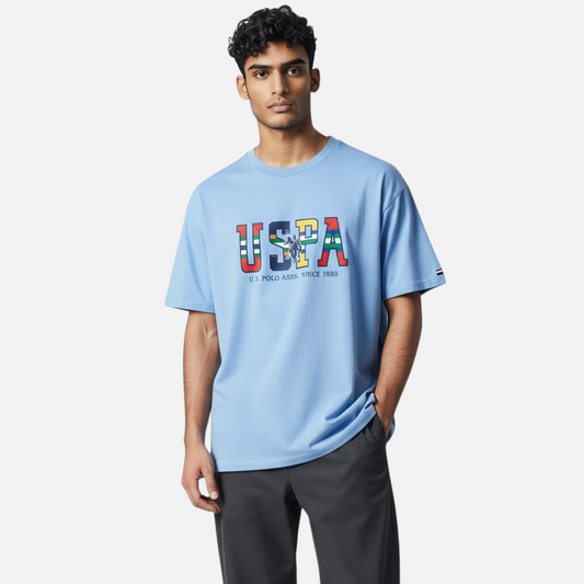Hombre vistiendo camiseta azul claro de algodón www.treshop.com.co con logo estampado multicolor en el pecho