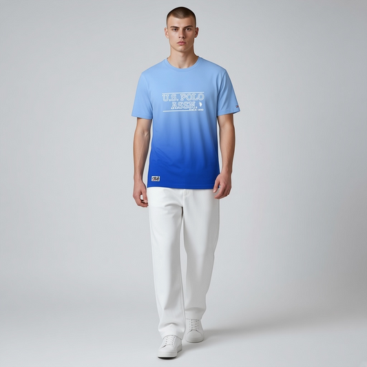 Hombre vistiendo camiseta www.treshop.com.co U.S. Polo Assn. azul con efecto degradado y logo estampado en el pecho