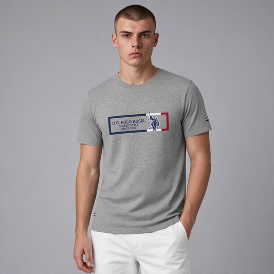 Hombre vistiendo camiseta gris jaspeado de algodón U.S. Polo Assn. con logo gráfico frontal y detalles en azul y rojo