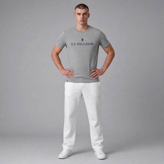 Hombre vistiendo camiseta gris jaspeado de manga corta www.treshop.com.co con logo U.S. POLO ASSN. en el pecho