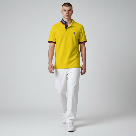 Hombre vistiendo polo amarillo www.treshop.com.co con cuello estampado y bordes en azul marino y rojo con pantalones