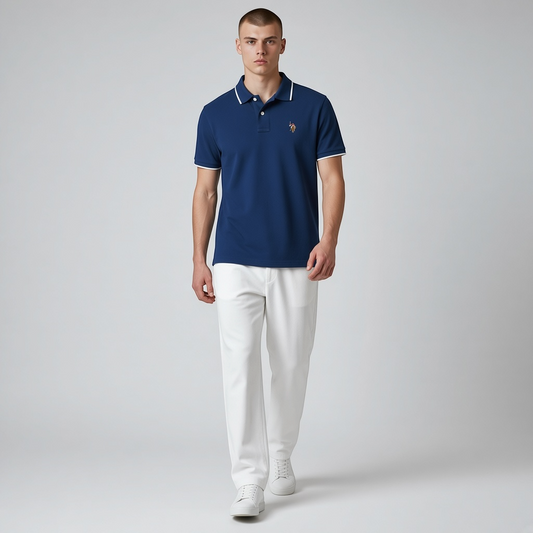 Hombre vistiendo polo azul marino www.treshop.com.co con detalles blancos en cuello y mangas y logo bordado