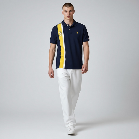Hombre vistiendo polo azul marino www.treshop.com.co con franja amarilla, número 3 y logo bordado, estilo deportivo.