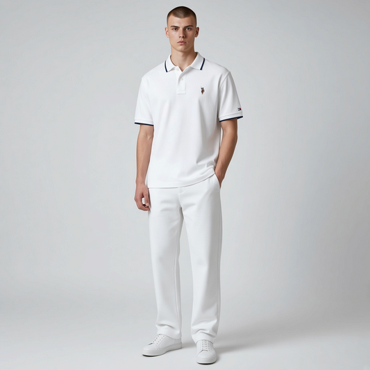 Hombre vistiendo polo blanco www.treshop.com.co con detalles en contraste, cuello clásico y logo bordado en el pecho.