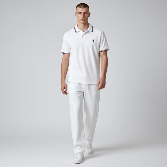 Hombre vistiendo polo blanco U.S. POLO ASSN. de www.treshop.com.co con detalles tricolores en cuello y mangas