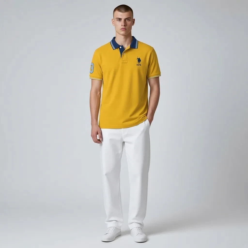 Modelo vistiendo polo amarillo www.treshop.com.co de algodón piqué con cuello azul y logo bordado en el pecho