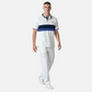 Hombre vistiendo polo www.treshop.com.co blanco de algodón piqué con franjas azul marino y logo bordado en el pecho. Marca U.S. Polo Assn.