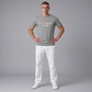 Hombre vistiendo camiseta gris jaspeado de algodón U.S. POLO ASSN. con logo frontal, combinada con pantalones blancos