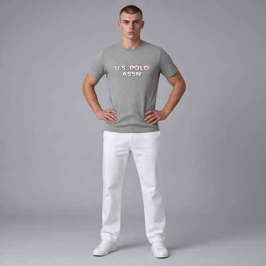 Hombre vistiendo camiseta gris jaspeado de algodón U.S. POLO ASSN. con logo frontal, combinada con pantalones blancos