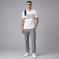 Hombre vistiendo polo blanco U.S. POLO ASSN. con estampado gráfico y logo bordado en www.treshop.com.co