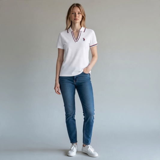 Modelo vistiendo polo blanco www.treshop.com.co con cuello en V y detalles tricolores, combinado con jeans azules.
