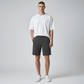 Hombre vistiendo bermuda gris oscuro de www.treshop.com.co con camiseta blanca y zapatillas en estudio