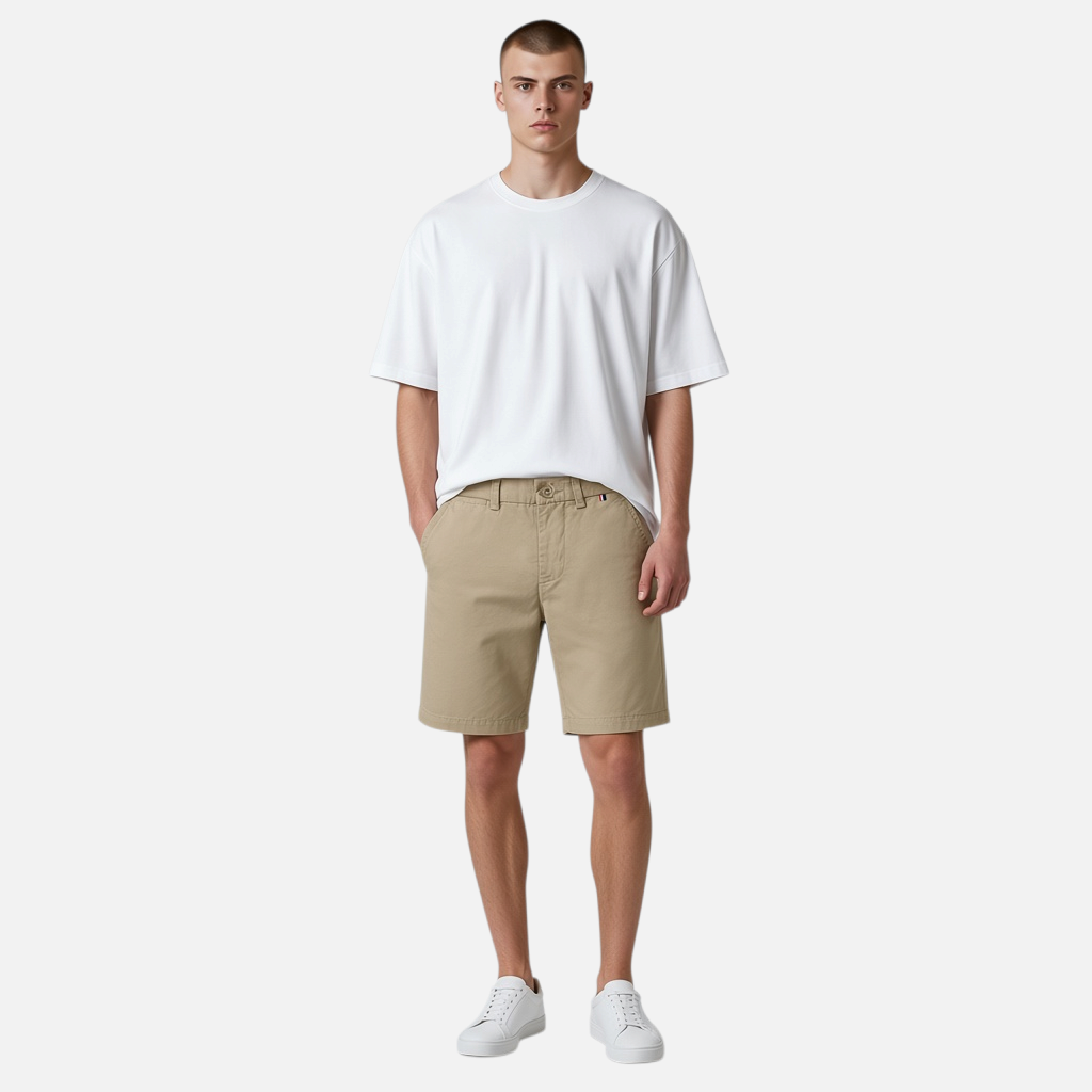 Hombre vistiendo bermudas beige de algodón de www.treshop.com.co con camiseta blanca y zapatillas casuales