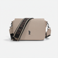 Bolso bandolera beige www.treshop.com.co con textura granulada y correa ajustable con logo de U.S. Polo Assn.