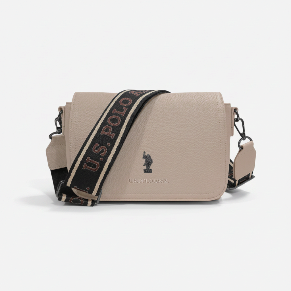 Bolso bandolera beige www.treshop.com.co con textura granulada y correa ajustable con logo de U.S. Polo Assn.
