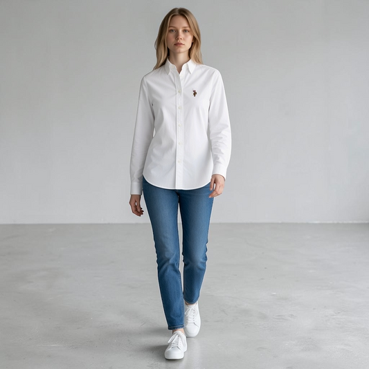 Modelo vistiendo camisa blanca de manga larga U.S. POLO ASSN. con jeans y zapatillas, disponible en www.treshop.com.co