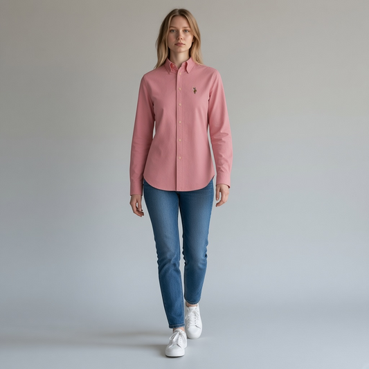 Modelo vistiendo camisa formal rosa de manga larga U.S. Polo Assn. de www.treshop.com.co con jeans y tenis blancos