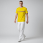 Hombre vistiendo camiseta amarilla de algodón www.treshop.com.co con logo y franja tricolor, combinada con pantalón blanco