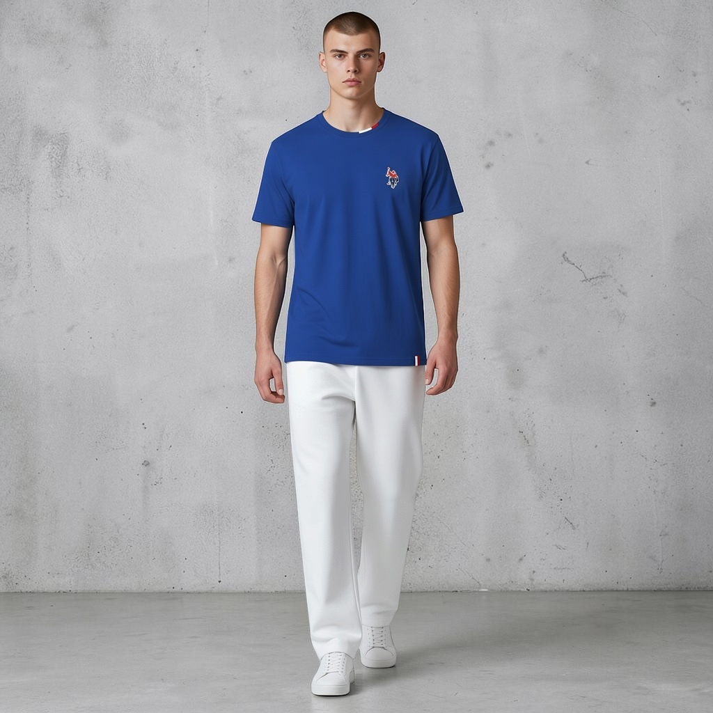 Hombre vistiendo camiseta azul de algodón www.treshop.com.co con logo bordado y detalles tricolores en el cuello
