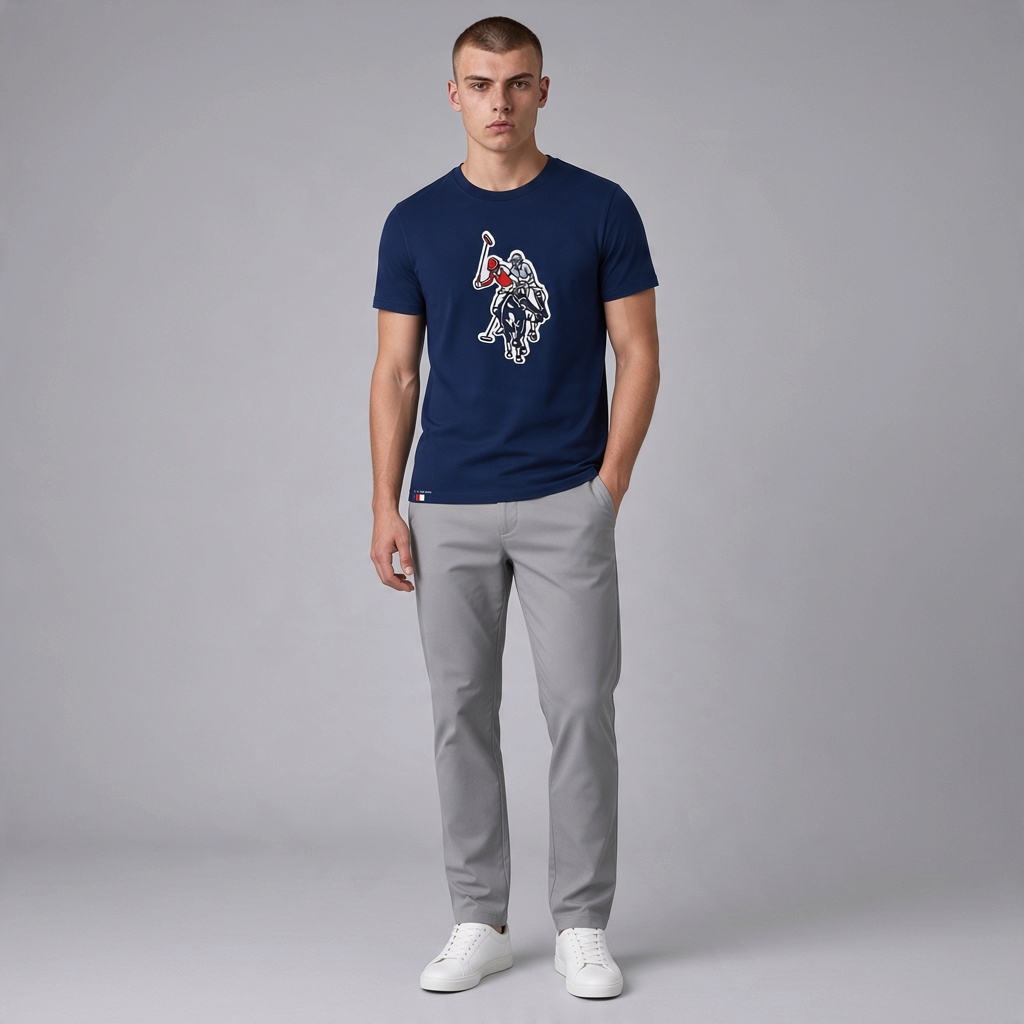 Hombre vistiendo camiseta azul marino de algodón U.S. POLO ASSN. con estampado frontal y pantalones grises