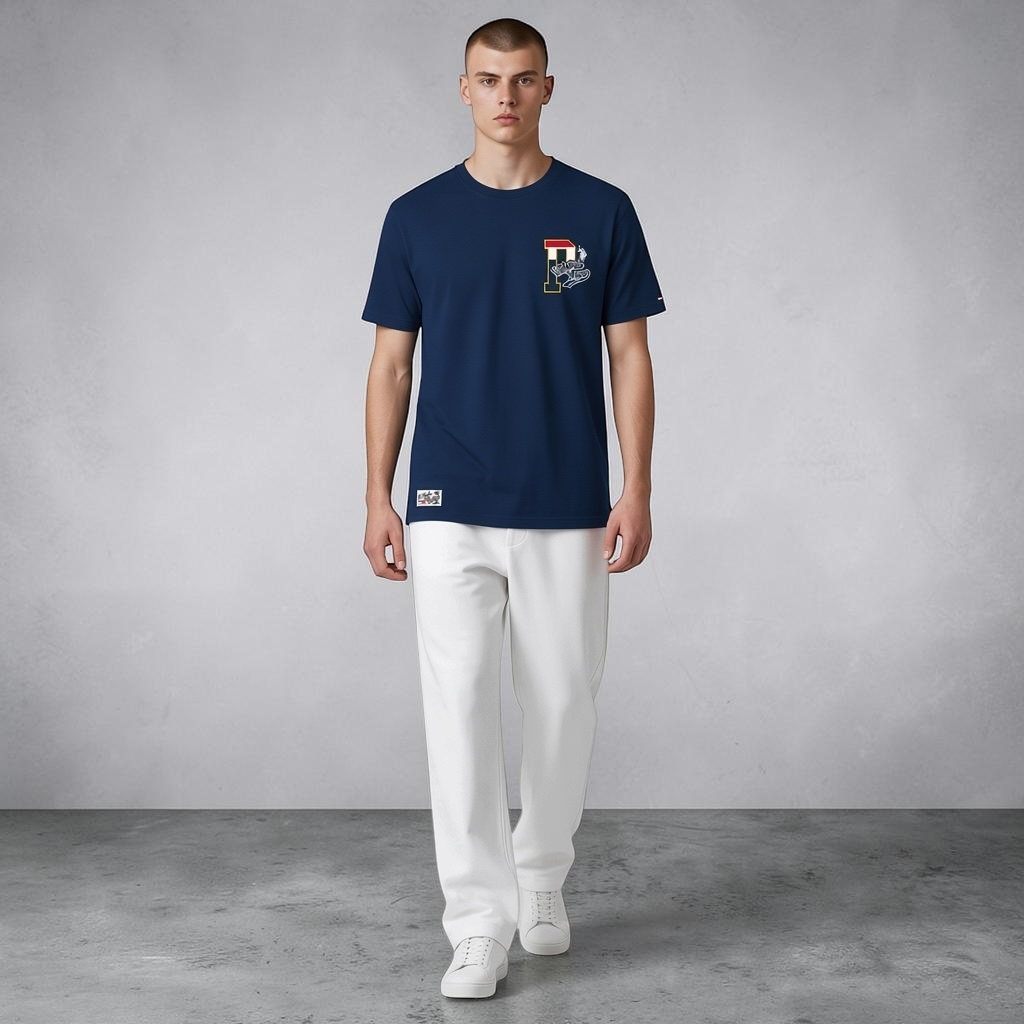 Hombre vistiendo camiseta azul marino de algodón U.S. Polo Assn. con estampado frontal y pantalones blancos
