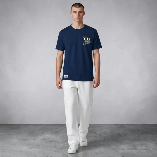 Hombre vistiendo camiseta azul marino de algodón U.S. Polo Assn. con estampado frontal y pantalones blancos