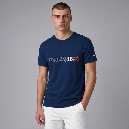 Hombre vistiendo camiseta azul marino de www.treshop.com.co con logo USPA 1890 y cuello redondo en estudio