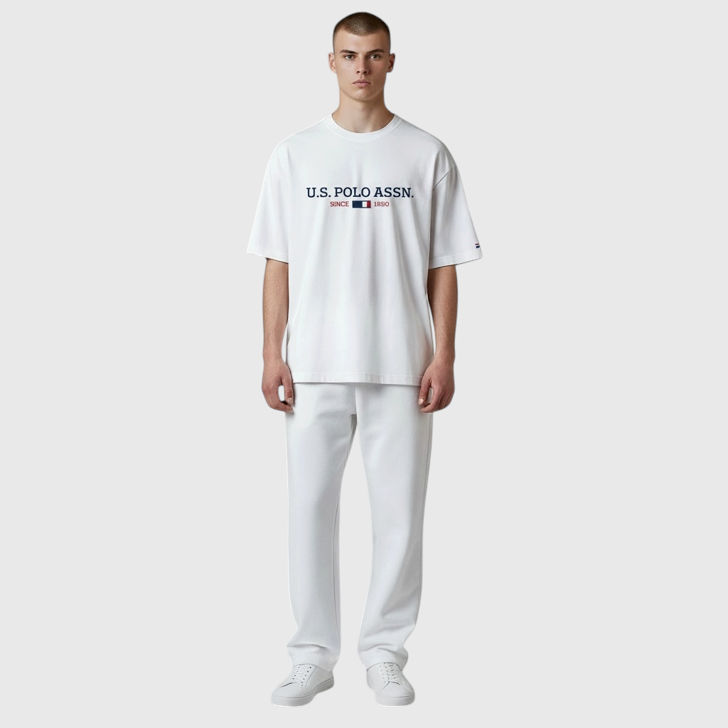 Hombre vistiendo camiseta blanca de algodón U.S. POLO ASSN. con logo frontal y pantalones a juego en www.treshop.com.co