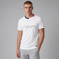 Camiseta blanca de algodón www.treshop.com.co con cuello tricolor y logo bordado, vestida por un modelo masculino.