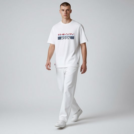 Hombre vistiendo camiseta blanca de algodón U.S. Polo Assn. con logo estampado y cuello redondo sobre fondo gris
