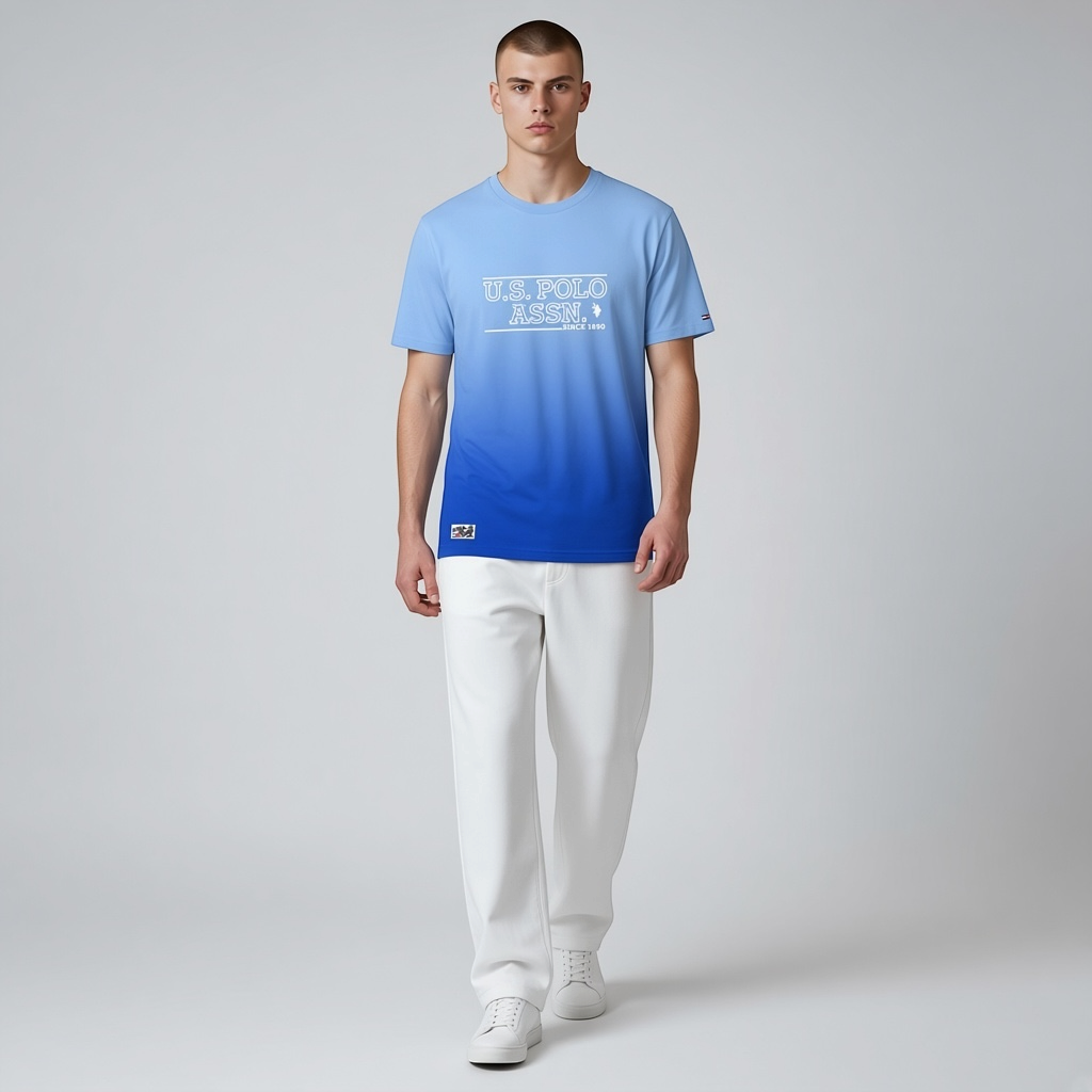 Hombre vistiendo camiseta www.treshop.com.co U.S. Polo Assn. azul con efecto degradado y logo estampado en el pecho