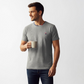 Hombre vistiendo camiseta gris de algodon www.treshop.com.co con logo de goma y cuello tricolor, estilo casual