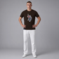 Hombre vistiendo camiseta marron de manga corta www.treshop.com.co con logo bordado grande en el pecho y pantalon blanco
