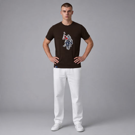 Hombre vistiendo camiseta marron de manga corta www.treshop.com.co con logo bordado grande en el pecho y pantalon blanco