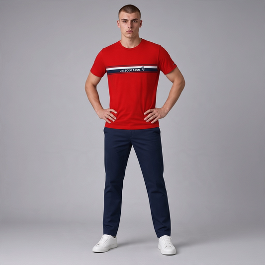 Camiseta roja de algodón U.S. POLO ASSN. con franja horizontal y logo, lucida por un modelo con pantalones azul marino.