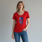 Mujer vistiendo camiseta roja de manga corta www.treshop.com.co con logo gráfico y formas geométricas azules