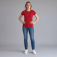 Modelo vistiendo camiseta roja de mujer www.treshop.com.co con logo bordado, combinada con jeans y tenis blancos
