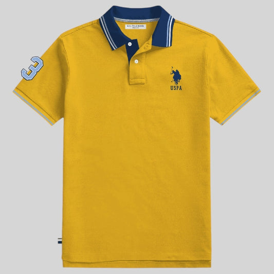 Camisa polo www.treshop.com.co color amarillo mostaza con cuello azul marino, logo bordado y detalle de numero 3