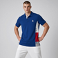Hombre vistiendo polo azul de www.treshop.com.co con panel lateral tricolor, logo bordado y cuello clásico.