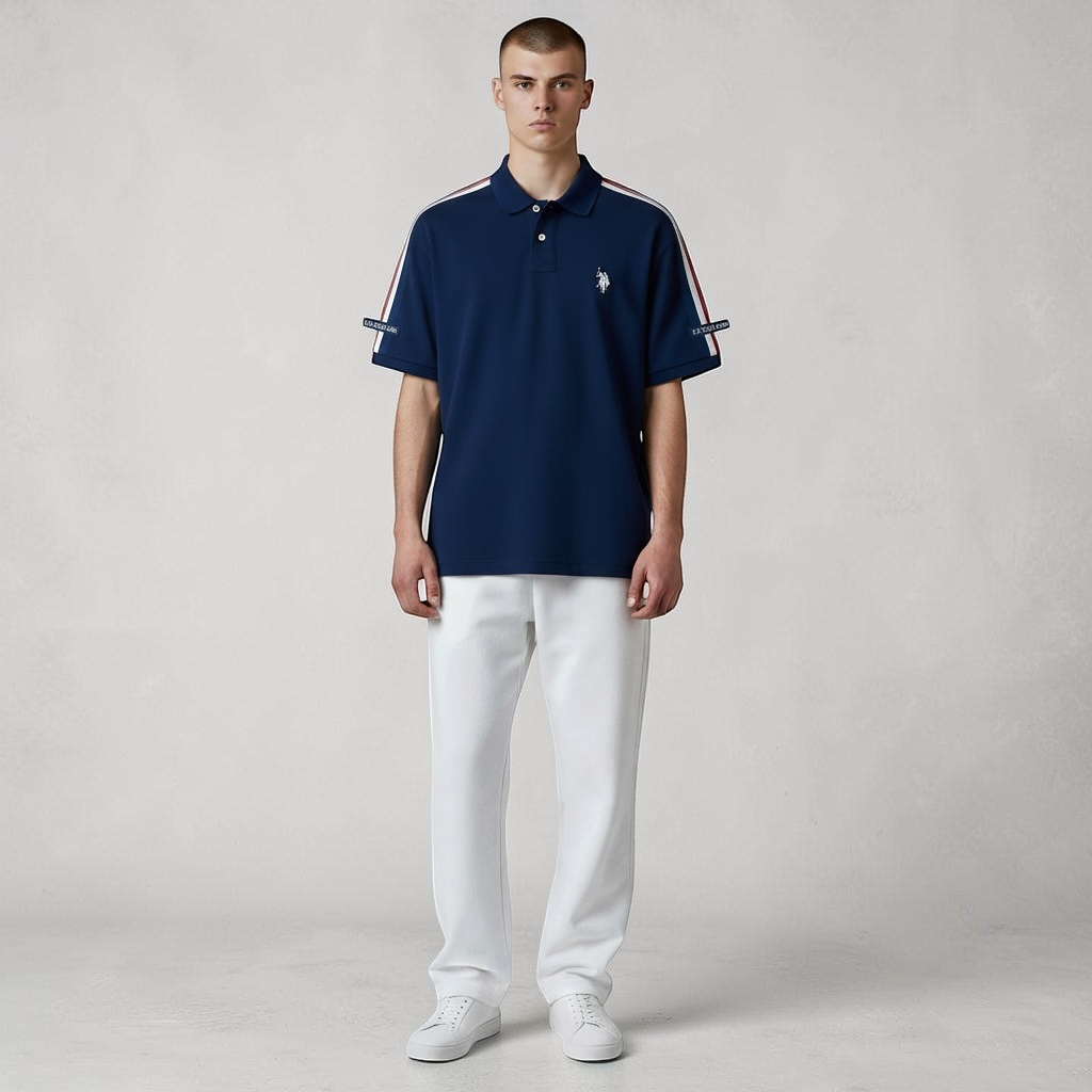 Hombre vistiendo polo azul marino www.treshop.com.co con franjas en mangas y logo bordado, combinado con pantalón blanco