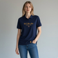 Mujer vistiendo polo azul marino www.treshop.com.co con logo dorado y detalles estampados en el pecho