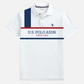 Camiseta polo blanca para hombre de www.treshop.com.co con estampado gráfico frontal y logo bordado de U.S. POLO ASSN.
