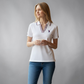 Mujer vistiendo polo blanco U.S. POLO ASSN. de www.treshop.com.co con cuello en V y detalles tricolores