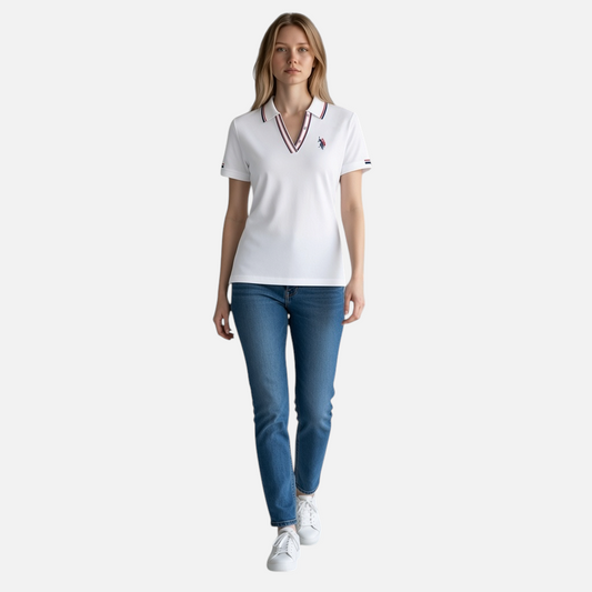 Modelo vistiendo polo blanco www.treshop.com.co con cuello en V, detalles tricolores y logo bordado en el pecho.