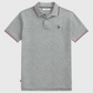 Polo gris jaspeado de algodón www.treshop.com.co con ribetes tricolor en cuello y mangas y logo bordado en el pecho