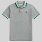 Polo www.treshop.com.co gris de algodón piqué con cuello y mangas a rayas verdes y azul marino y logo de goma