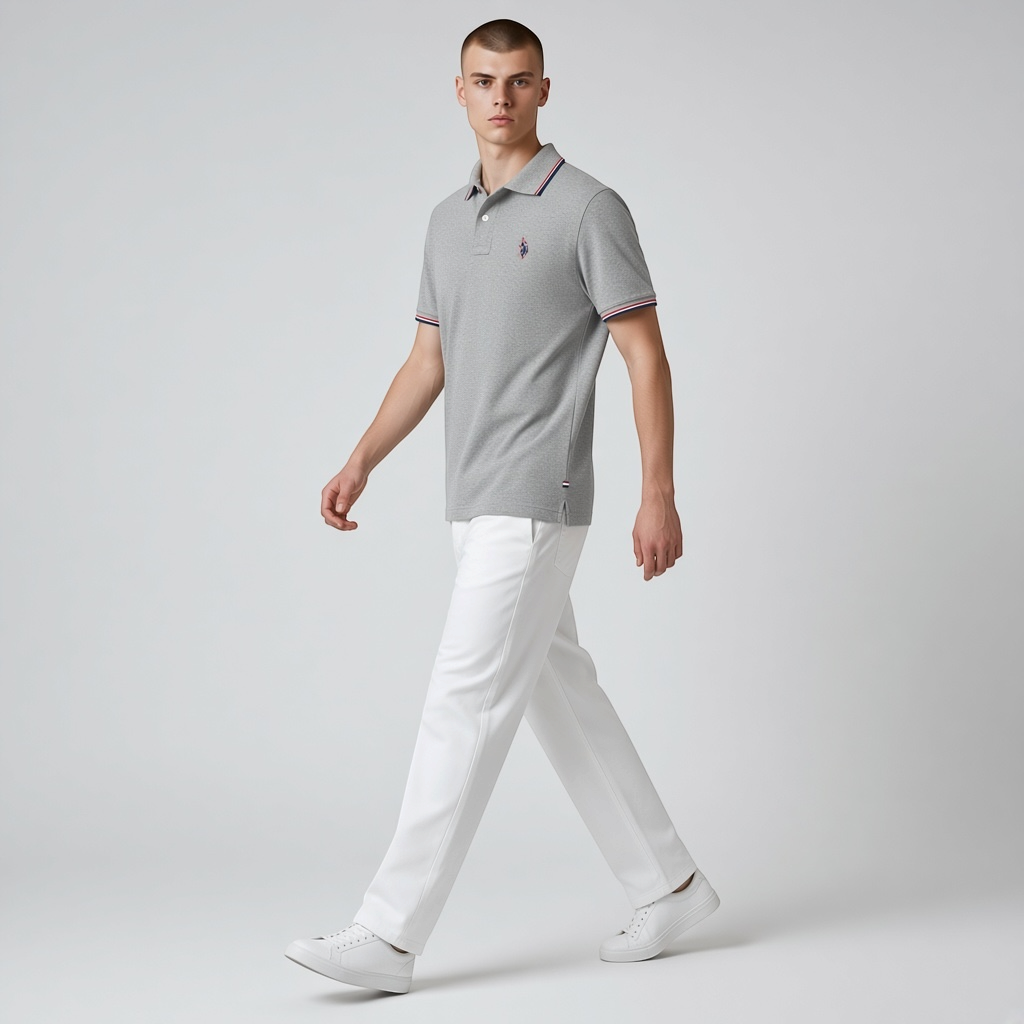 Modelo vistiendo polo gris de algodón www.treshop.com.co con ribetes tricolor y logo bordado, combinado con pantalón