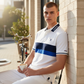 Hombre con polo blanco y azul de www.treshop.com.co con bloques de color, cuello con logo y diseño casual elegante