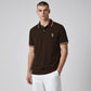 Modelo vistiendo polo marrón oscuro U.S. Polo Assn. con detalles en contraste en cuello y mangas y logo bordado